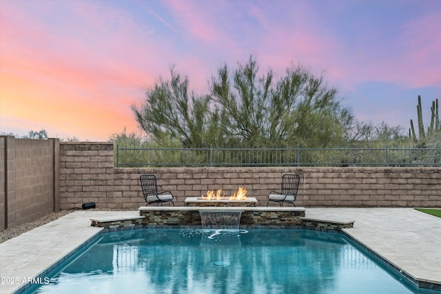 pool at dusk featuring a fenced in pool, a patio, a fire pit, and a fenced backyard