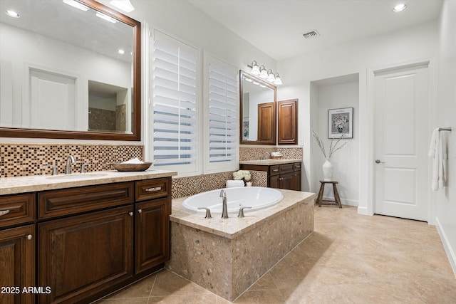 bathroom featuring visible vents, a garden tub, backsplash, recessed lighting, and vanity