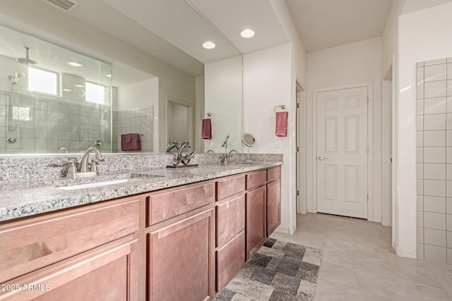 bathroom featuring tile patterned flooring, vanity, and walk in shower