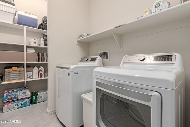 clothes washing area featuring light tile patterned floors and washing machine and clothes dryer