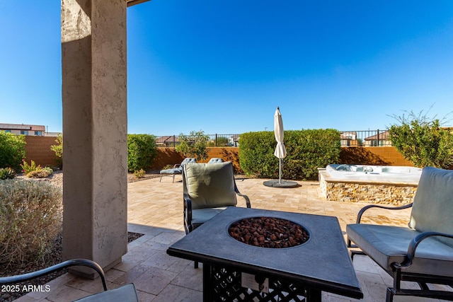 view of patio / terrace with a hot tub and a fire pit