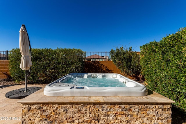 view of swimming pool with a hot tub