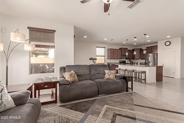 tiled living room featuring ceiling fan and sink