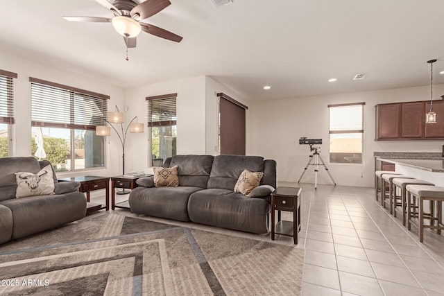 living room featuring ceiling fan, plenty of natural light, and light tile patterned floors