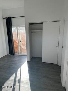 unfurnished bedroom with a closet and dark hardwood / wood-style floors