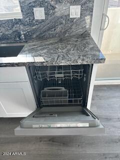 room details with dark stone countertops and white cabinetry