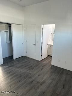 unfurnished bedroom featuring connected bathroom, a closet, and dark hardwood / wood-style floors