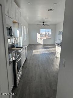 kitchen featuring ceiling fan, dark wood-type flooring, sink, white cabinetry, and stainless steel range with electric stovetop