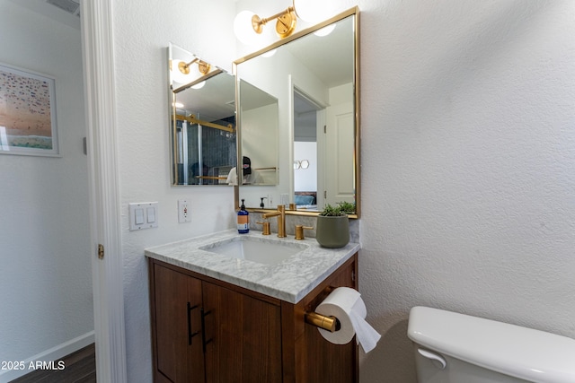 15221 N Clubgate Dr Unit 2132, Scottsdale, AZ 85254 - bathroom with baseboards, toilet, vanity, and a textured wall