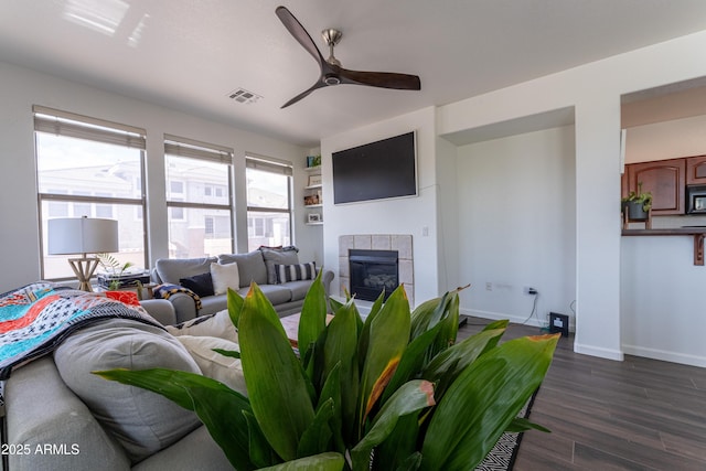 15221 N Clubgate Dr Unit 2132, Scottsdale, AZ 85254 - living area featuring ceiling fan, a tile fireplace, baseboards, dark wood-type flooring, and visible vents