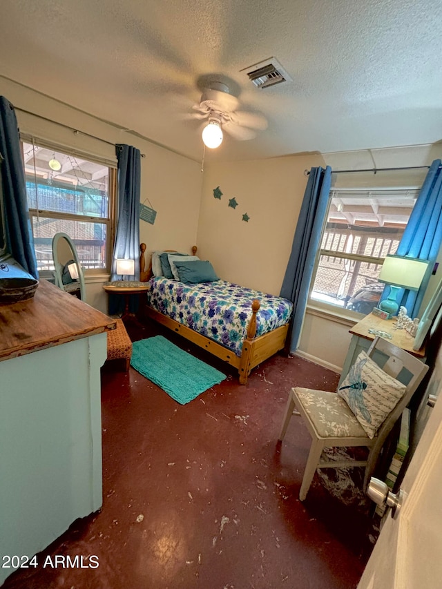 bedroom featuring multiple windows, a textured ceiling, and ceiling fan