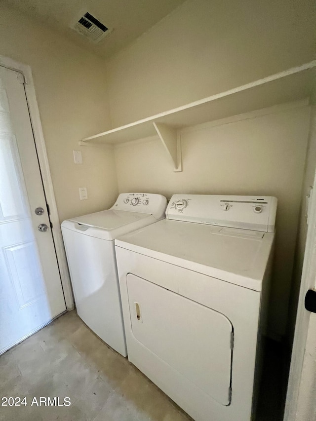 clothes washing area with separate washer and dryer