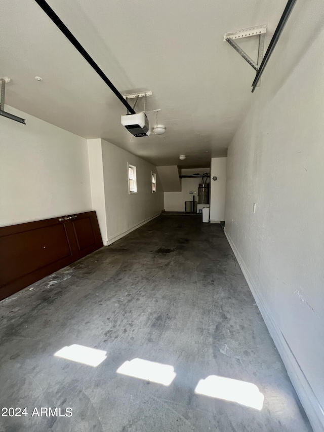 garage featuring a garage door opener and strapped water heater