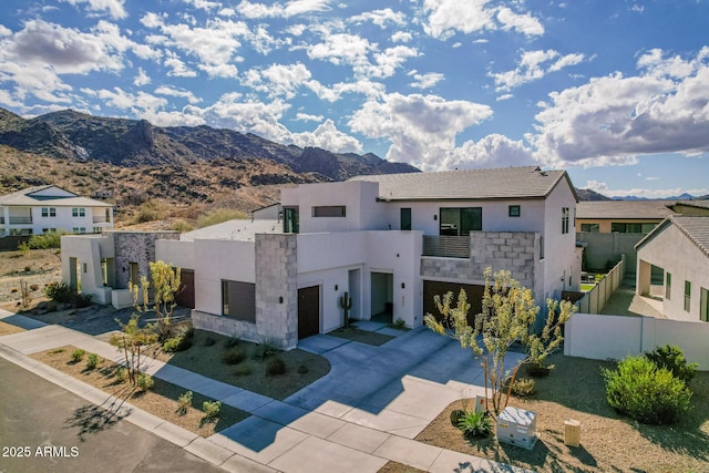 contemporary home with a garage, a balcony, and a mountain view