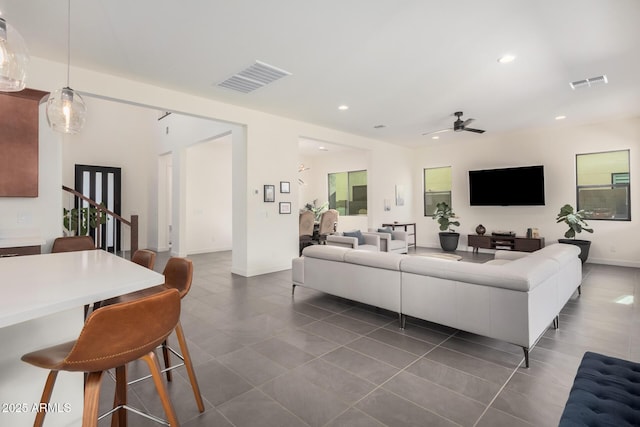 living room with dark tile patterned floors and ceiling fan