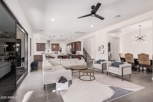 living room featuring tile patterned floors and ceiling fan with notable chandelier