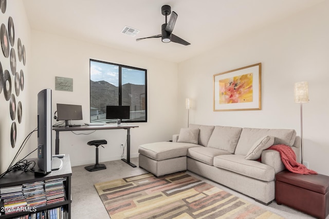 carpeted living room with ceiling fan