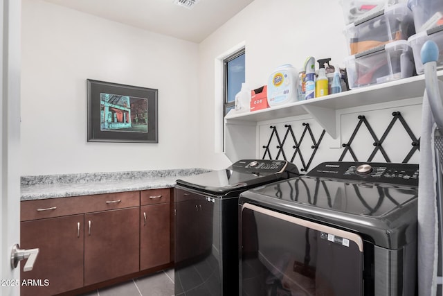 laundry area featuring light tile patterned flooring, independent washer and dryer, and cabinets