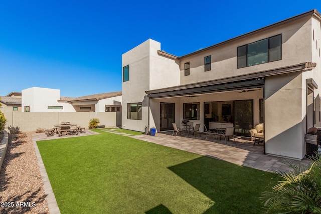 back of house with a patio area, ceiling fan, and a lawn