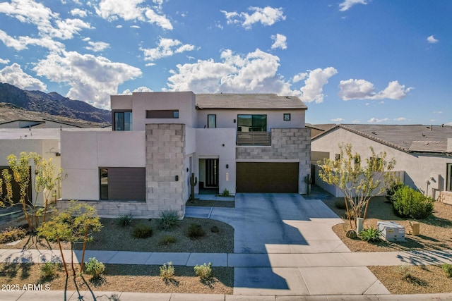 contemporary home with a mountain view, a garage, and a balcony