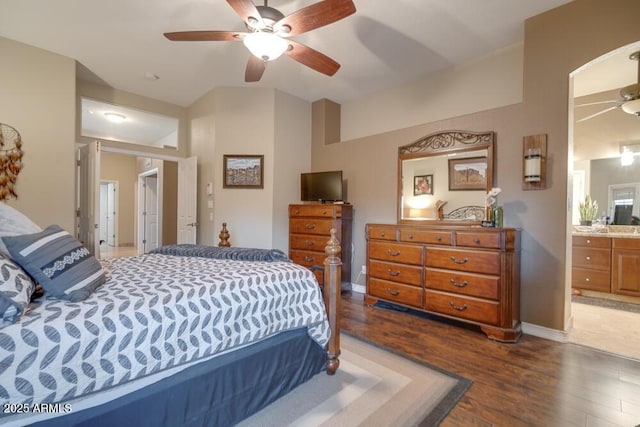 bedroom featuring dark hardwood / wood-style floors, ceiling fan, and ensuite bath