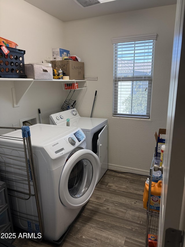 clothes washing area with wood finished floors, visible vents, baseboards, laundry area, and independent washer and dryer