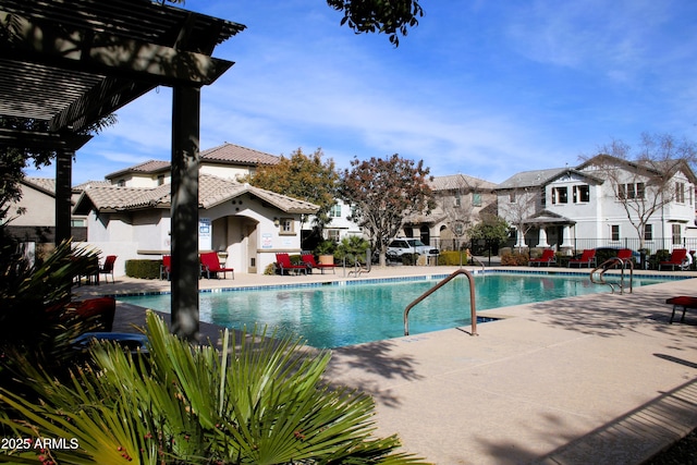 pool featuring a residential view, a patio, and fence