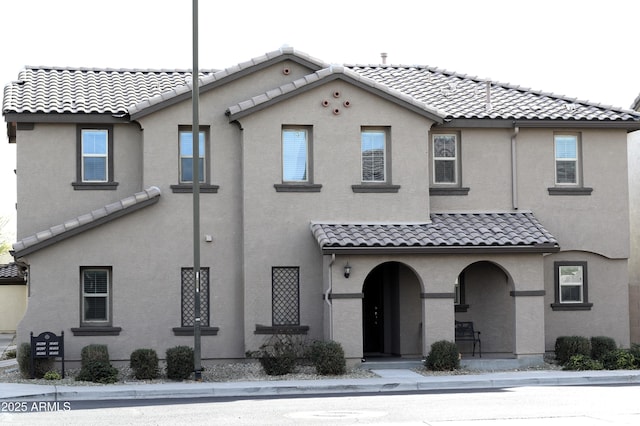 view of front of home featuring a tiled roof and stucco siding