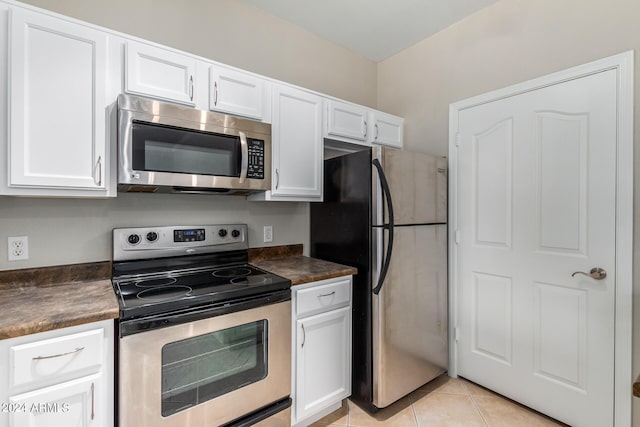 kitchen with white cabinets, light tile patterned floors, and appliances with stainless steel finishes