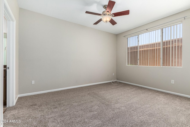 carpeted spare room with ceiling fan