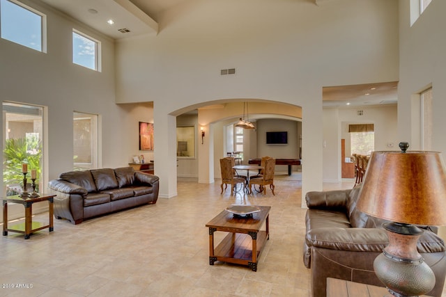 living room with a high ceiling and billiards