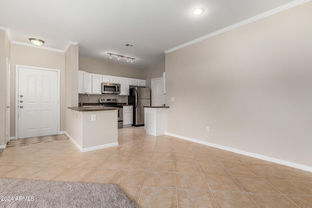 kitchen featuring ornamental molding, stainless steel appliances, sink, light tile patterned floors, and white cabinetry