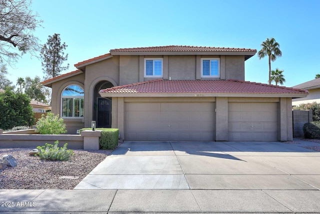 view of front of home featuring a tile roof, driveway, an attached garage, and stucco siding