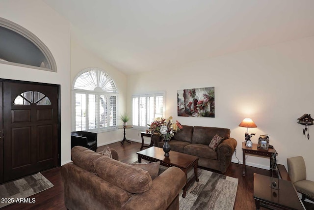 living room with dark wood-style floors, high vaulted ceiling, and baseboards