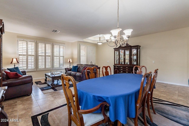 dining room with a notable chandelier and light tile patterned floors