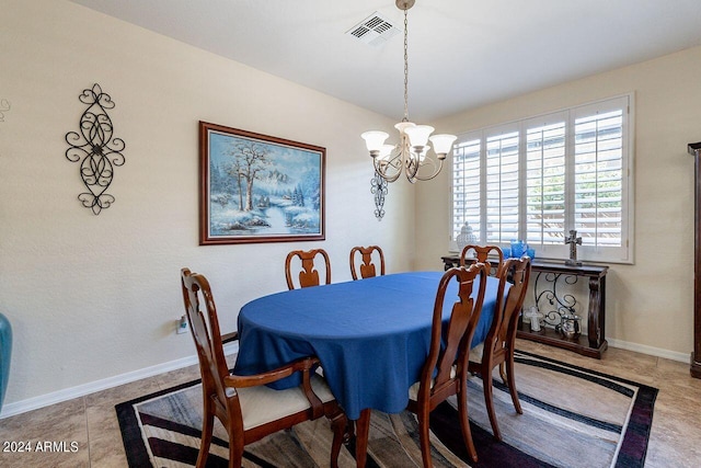 dining area featuring a notable chandelier and light tile patterned flooring