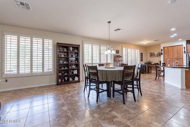 tiled dining area featuring sink and a notable chandelier