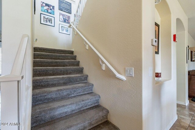 staircase featuring tile patterned flooring