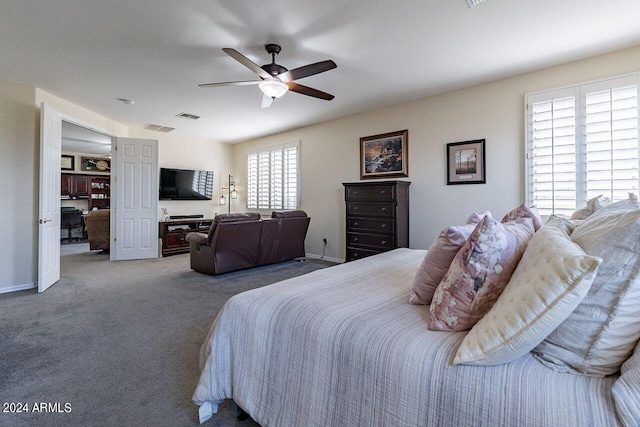 carpeted bedroom with ceiling fan and multiple windows