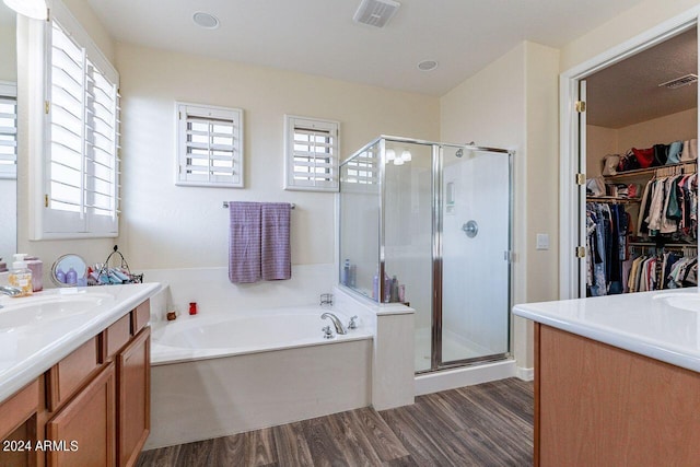 bathroom with vanity, wood-type flooring, and plus walk in shower