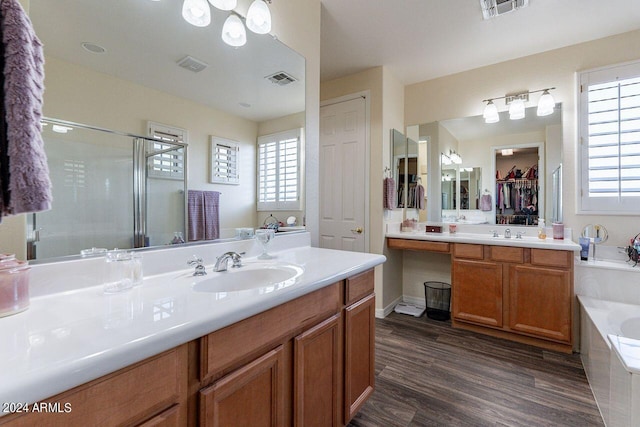 bathroom featuring vanity, hardwood / wood-style floors, and plus walk in shower