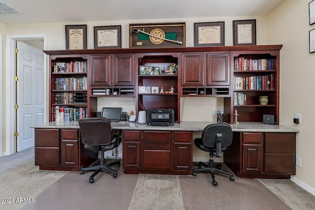 carpeted office space featuring built in desk