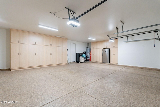 garage featuring gas water heater, a garage door opener, and stainless steel refrigerator