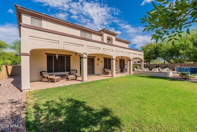 rear view of property with a patio area, a yard, and outdoor lounge area