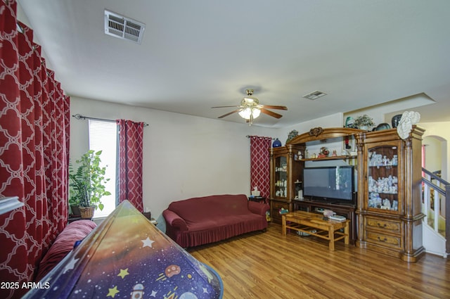 703 N Redwood Ln, Buckeye, AZ 85326 - living room featuring wood finished floors, a ceiling fan, and stairs