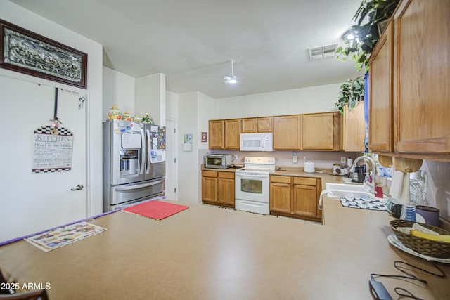 703 N Redwood Ln, Buckeye, AZ 85326 - kitchen featuring appliances with stainless steel finishes, a sink, a ceiling fan, light countertops, and a peninsula