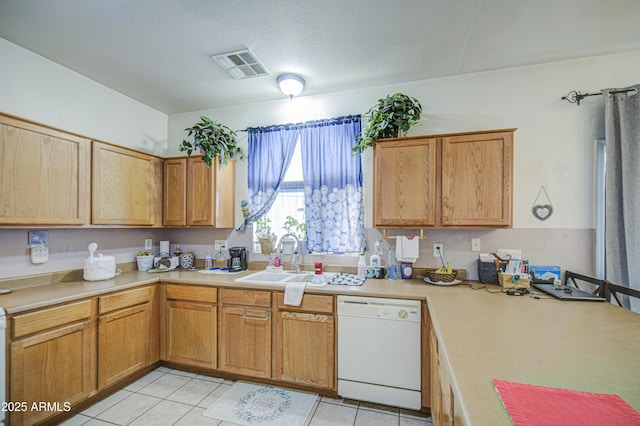 703 N Redwood Ln, Buckeye, AZ 85326 - kitchen with white dishwasher, a sink, light countertops, and light tile patterned floors