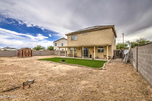 703 N Redwood Ln, Buckeye, AZ 85326 - rear view of house with roof mounted solar panels, a fenced backyard, a patio area, and stucco siding