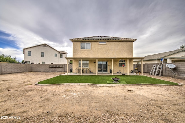703 N Redwood Ln, Buckeye, AZ 85326 - rear view of house featuring roof mounted solar panels, a patio area, stucco siding, and a tile roof