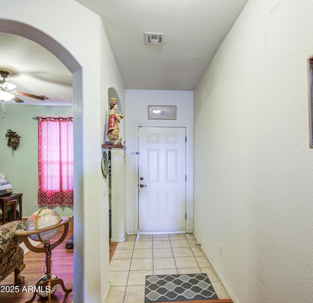 703 N Redwood Ln, Buckeye, AZ 85326 - hall featuring light tile patterned flooring, arched walkways, and baseboards